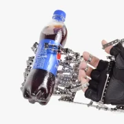 Mechanische hand vastgemaakt aan mensenhand en daarmee een frisdrank fles vasthouden